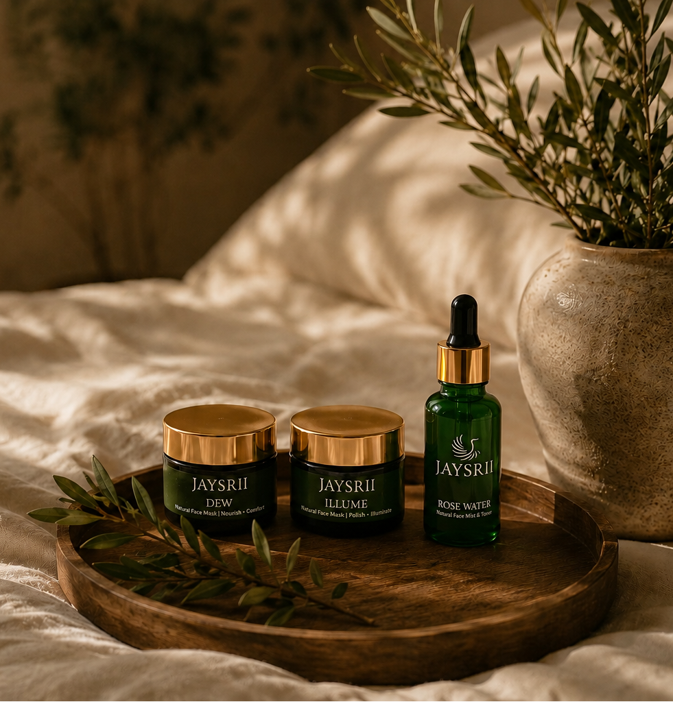 Three skincare products from the brand JAYSRII are arranged on a round wooden tray on a bed with white linens.